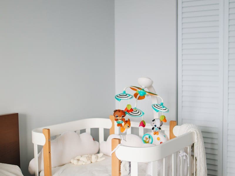 A baby sleeping on their back in a bare crib after transitioning out of a responsive bassinet