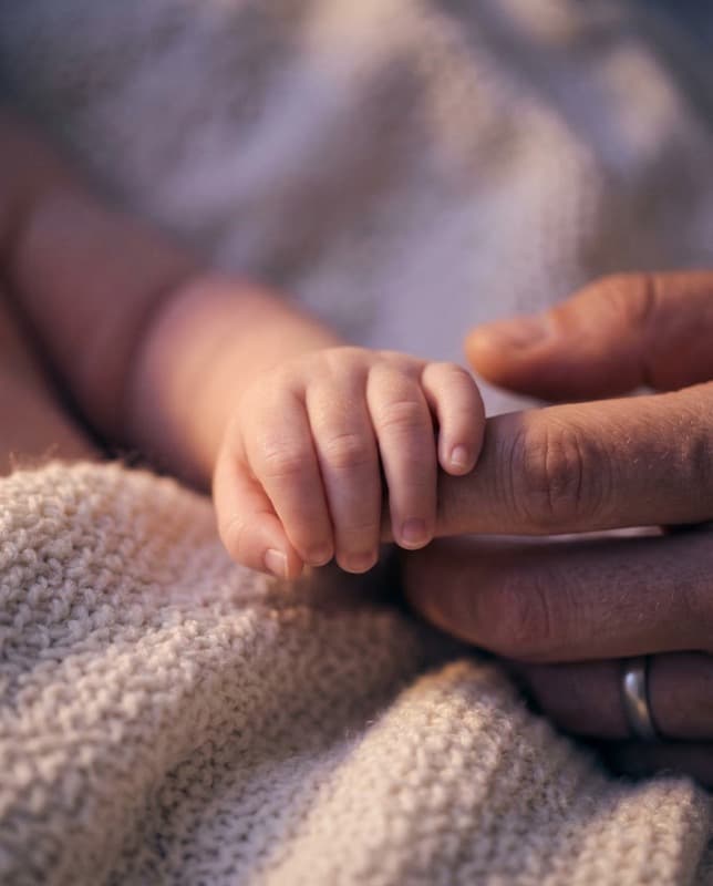 Baby's hand on soft blanket