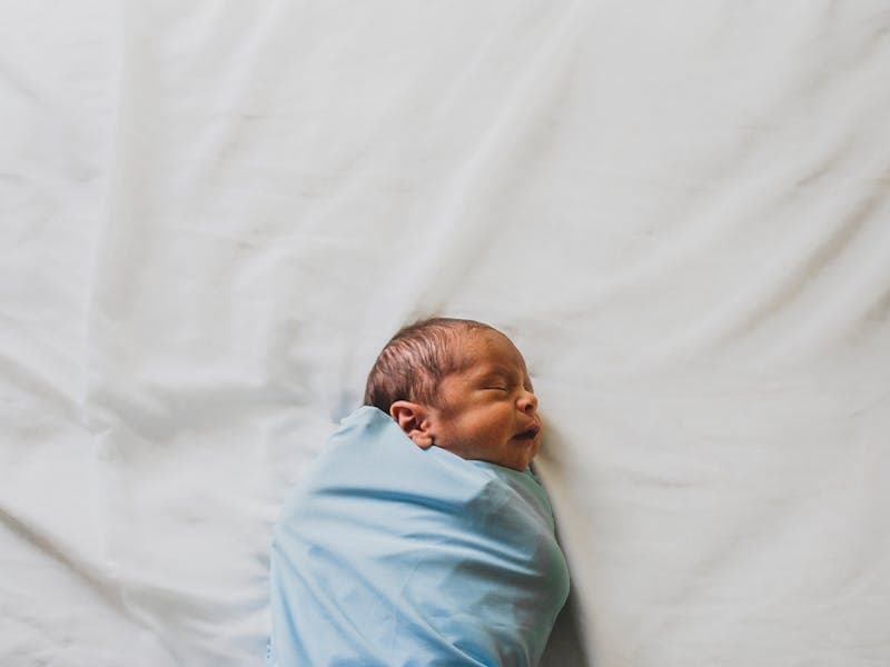 Baby sleeping on white bedding